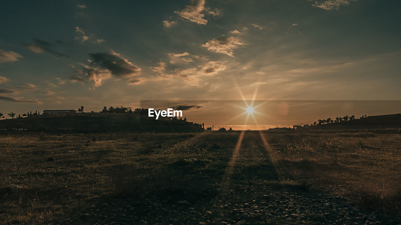 SCENIC VIEW OF SUNSET OVER FIELD