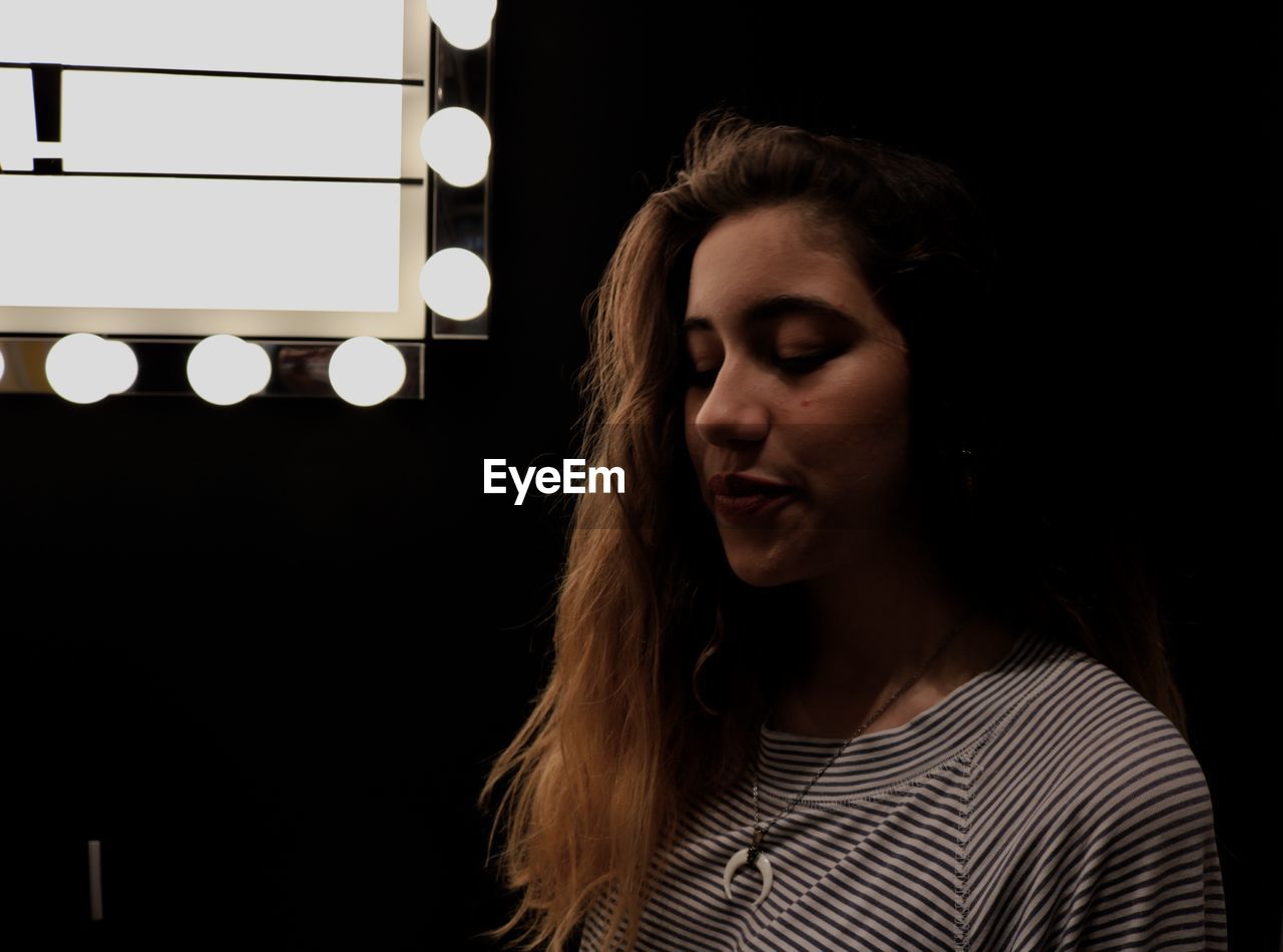 Beautiful woman with illuminated lights against black background