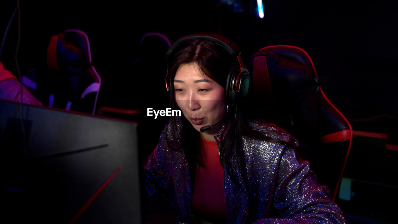 Young woman using computer in darkroom