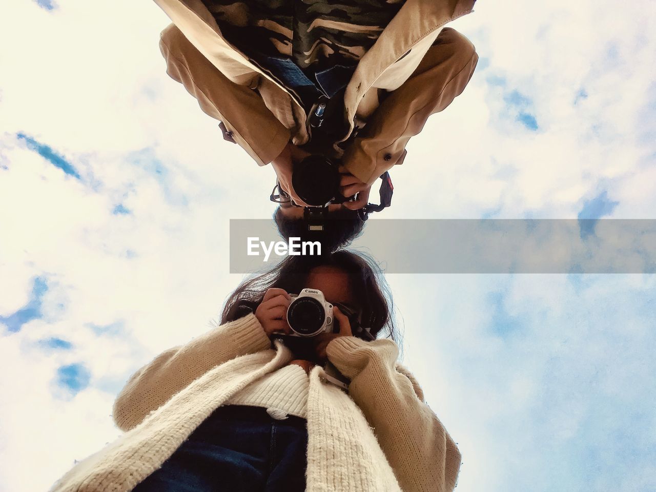 LOW ANGLE VIEW OF MAN CLIMBING AGAINST SKY