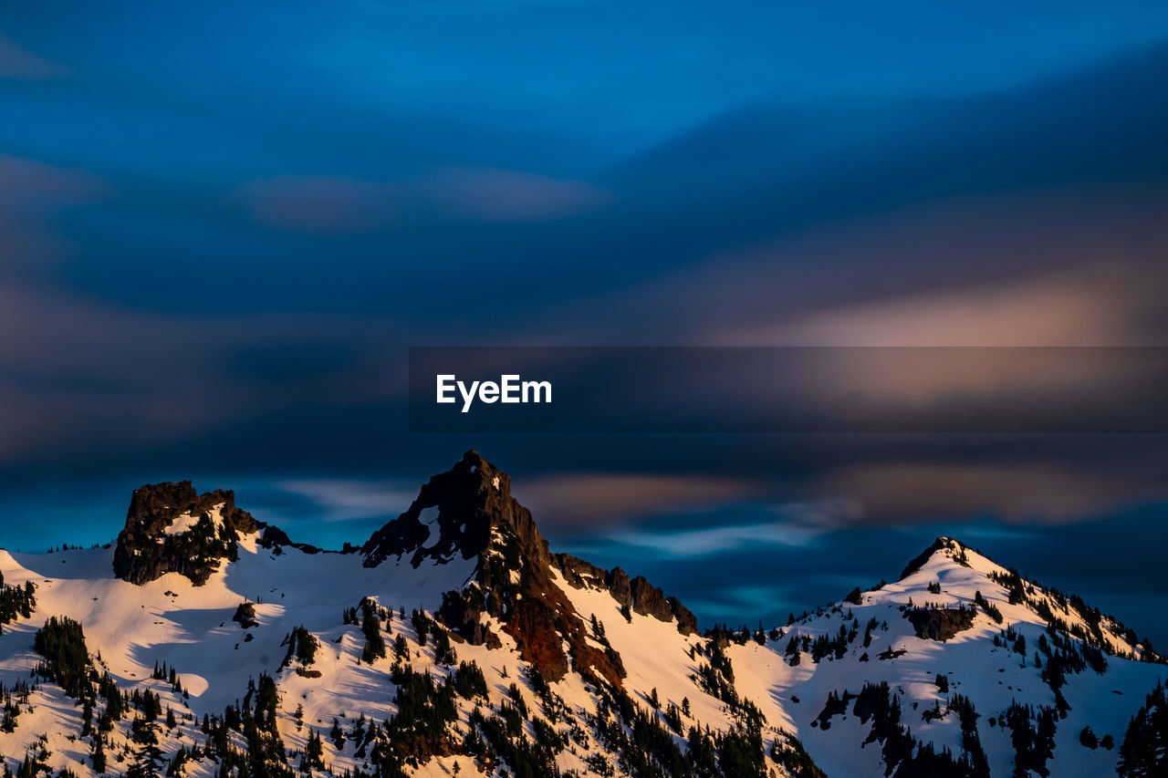 Scenic view of snowcapped mountains against sky during sunset