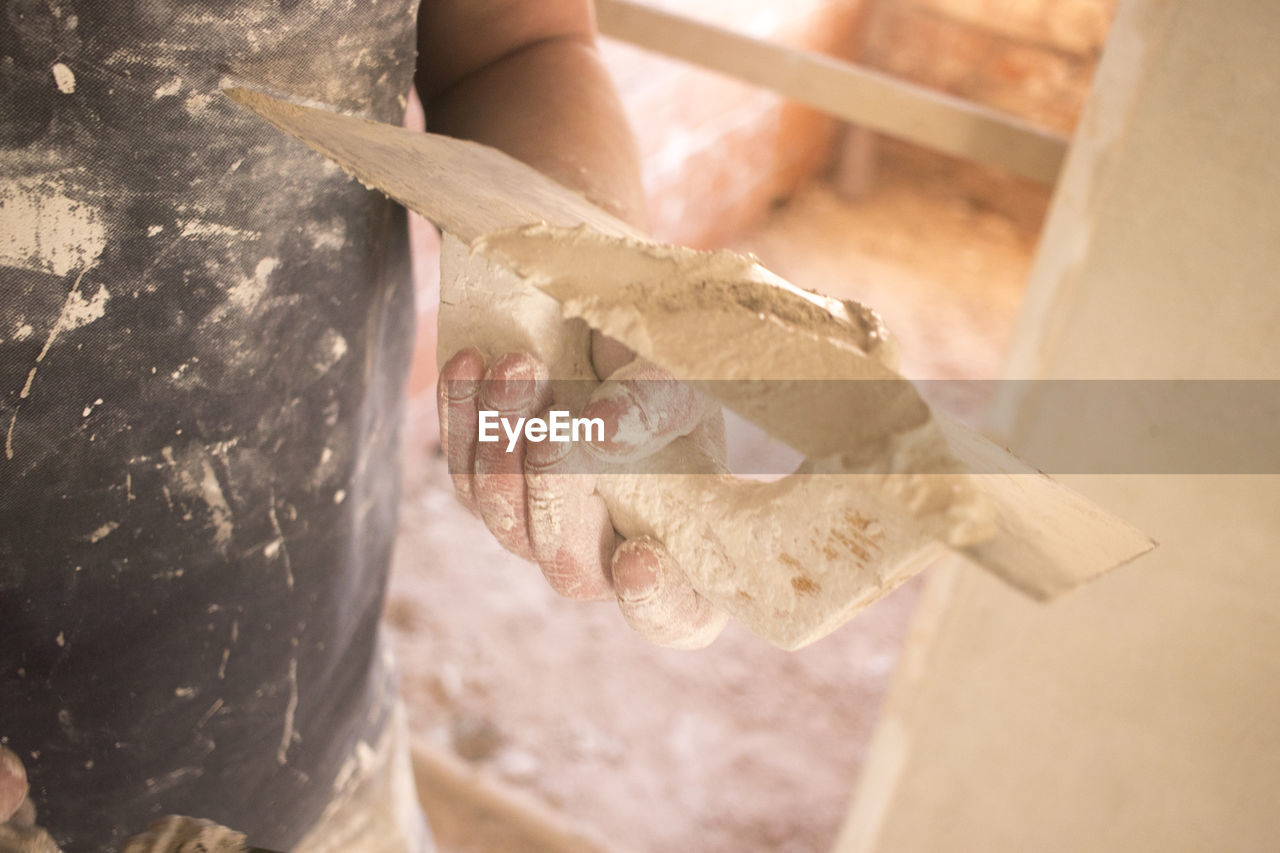 HIGH ANGLE VIEW OF HUMAN HAND ON WOOD