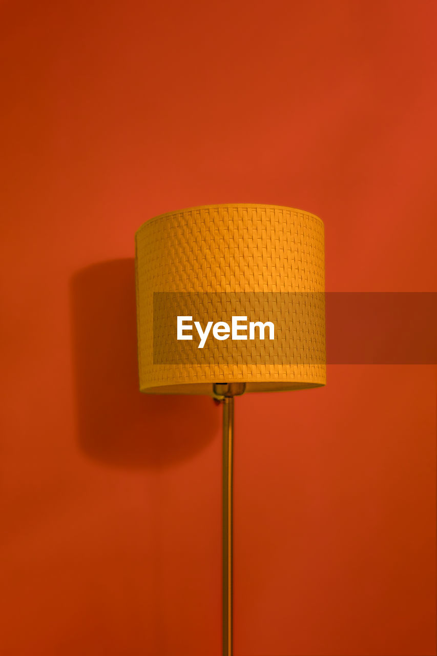 close-up of illuminated electric lamp against yellow background