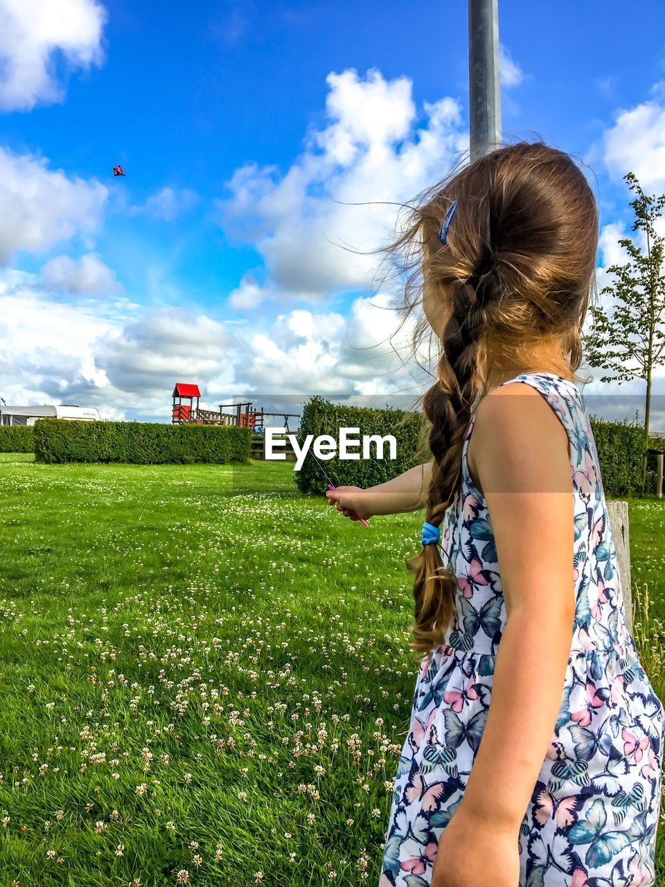 Girl playing on field against sky