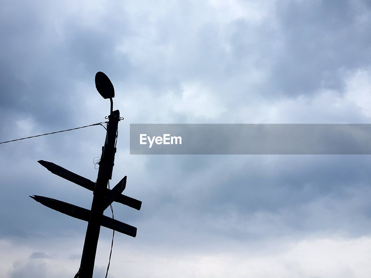 LOW ANGLE VIEW OF SILHOUETTE CRANE AGAINST CLOUDY SKY