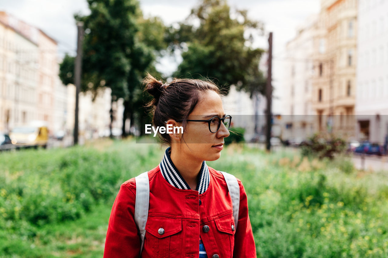 Young woman with eyeglasses looking away
