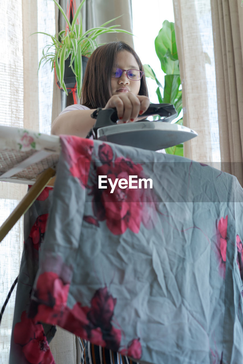 YOUNG WOMAN LOOKING AT CAMERA AT HOME