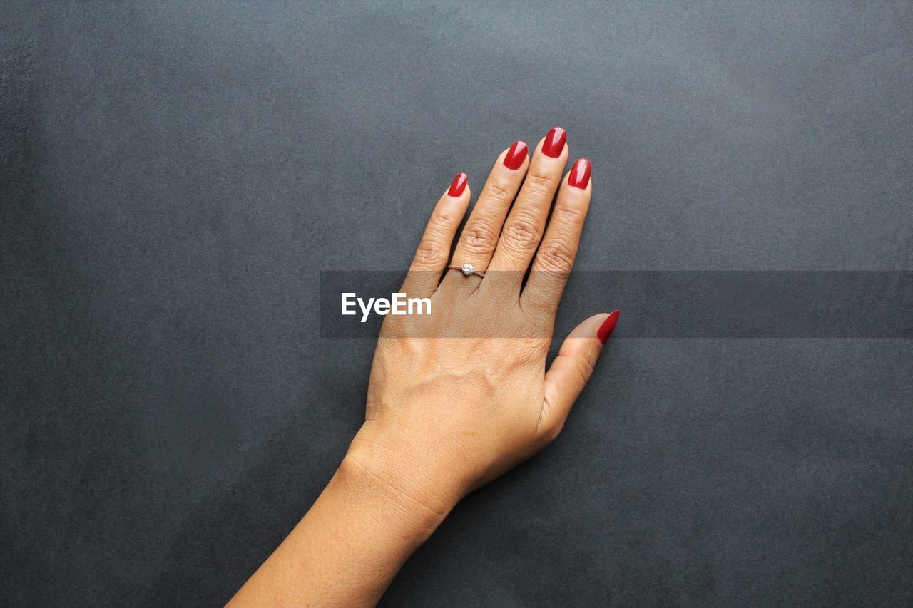 CLOSE-UP OF WOMAN HAND OVER BLACK BACKGROUND