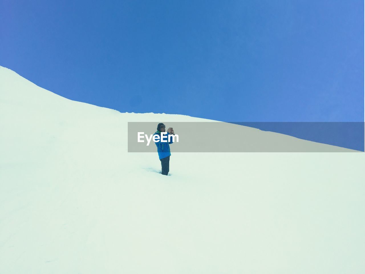 LOW ANGLE VIEW OF PERSON AGAINST CLEAR BLUE SKY