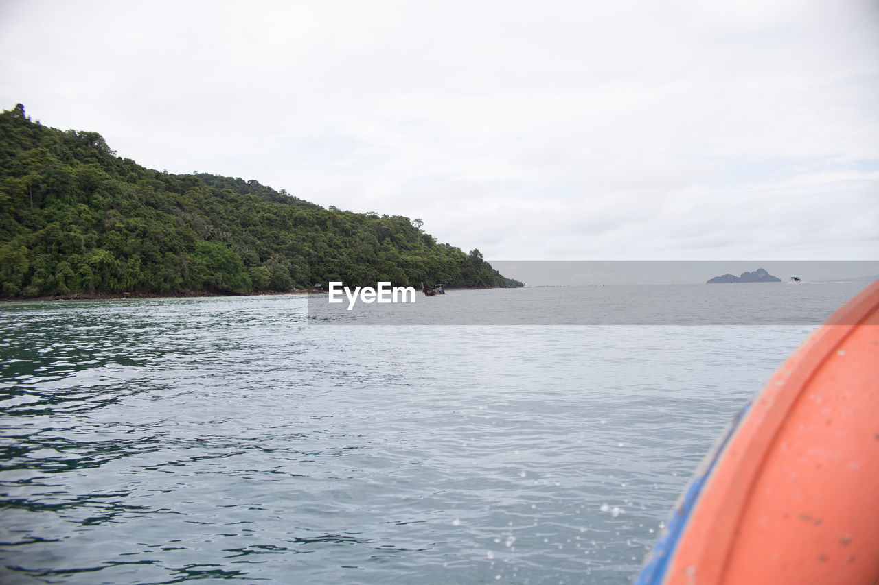 SCENIC VIEW OF SEA WITH MOUNTAIN IN BACKGROUND