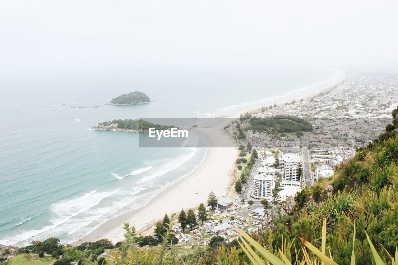 High angle view of city by sea against sky