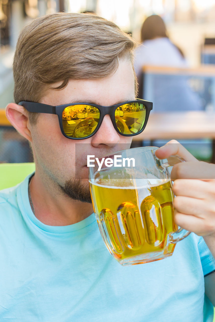 CLOSE-UP PORTRAIT OF MAN DRINKING GLASSES