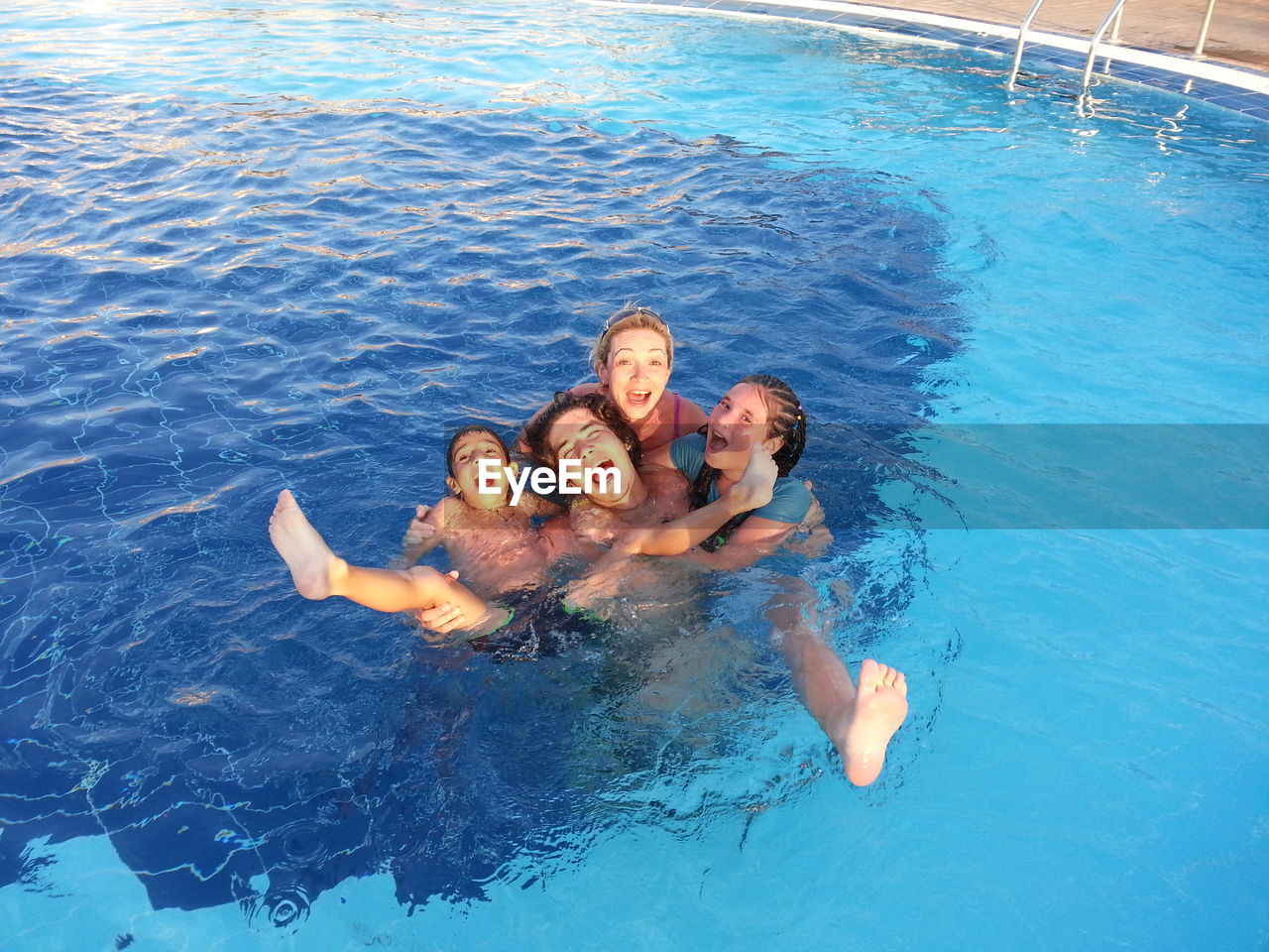 Portrait of cheerful family in swimming pool