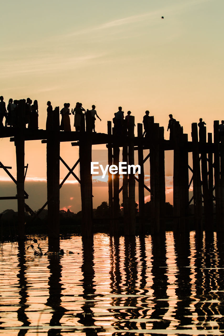 SILHOUETTE PEOPLE STANDING ON PIER OVER SEA AGAINST SKY