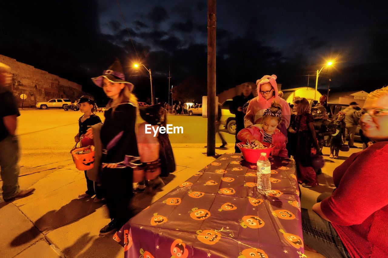 PEOPLE ON STREET AT NIGHT IN CITY