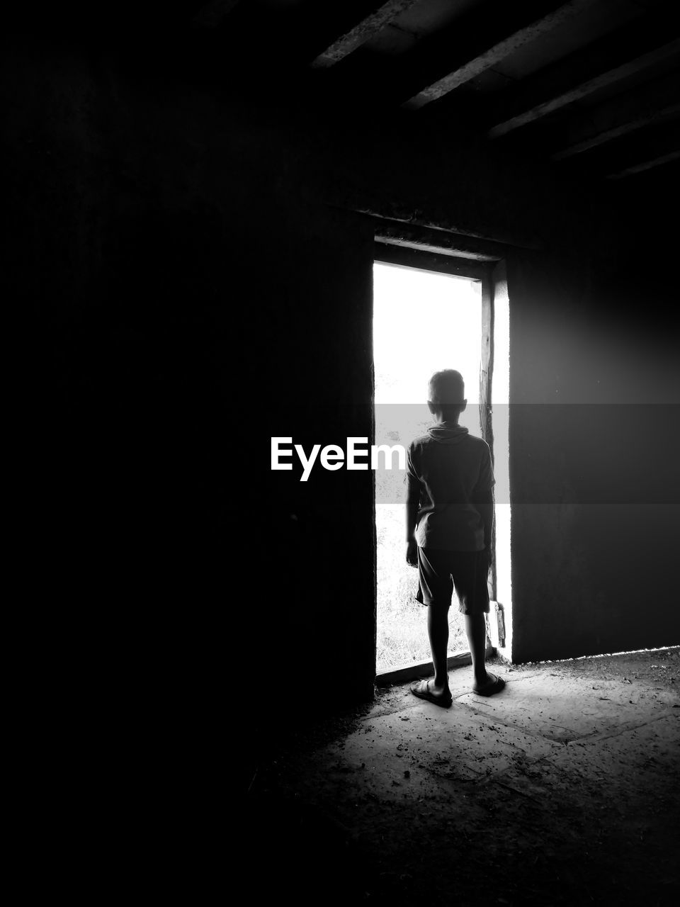 Rear view of boy standing by door