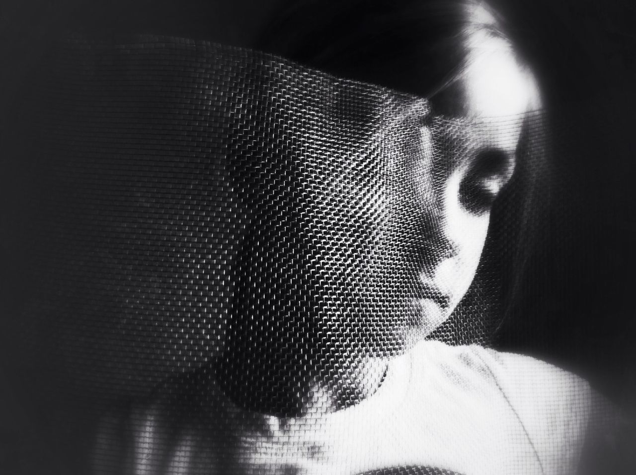 Close-up of a sad girl against black background
