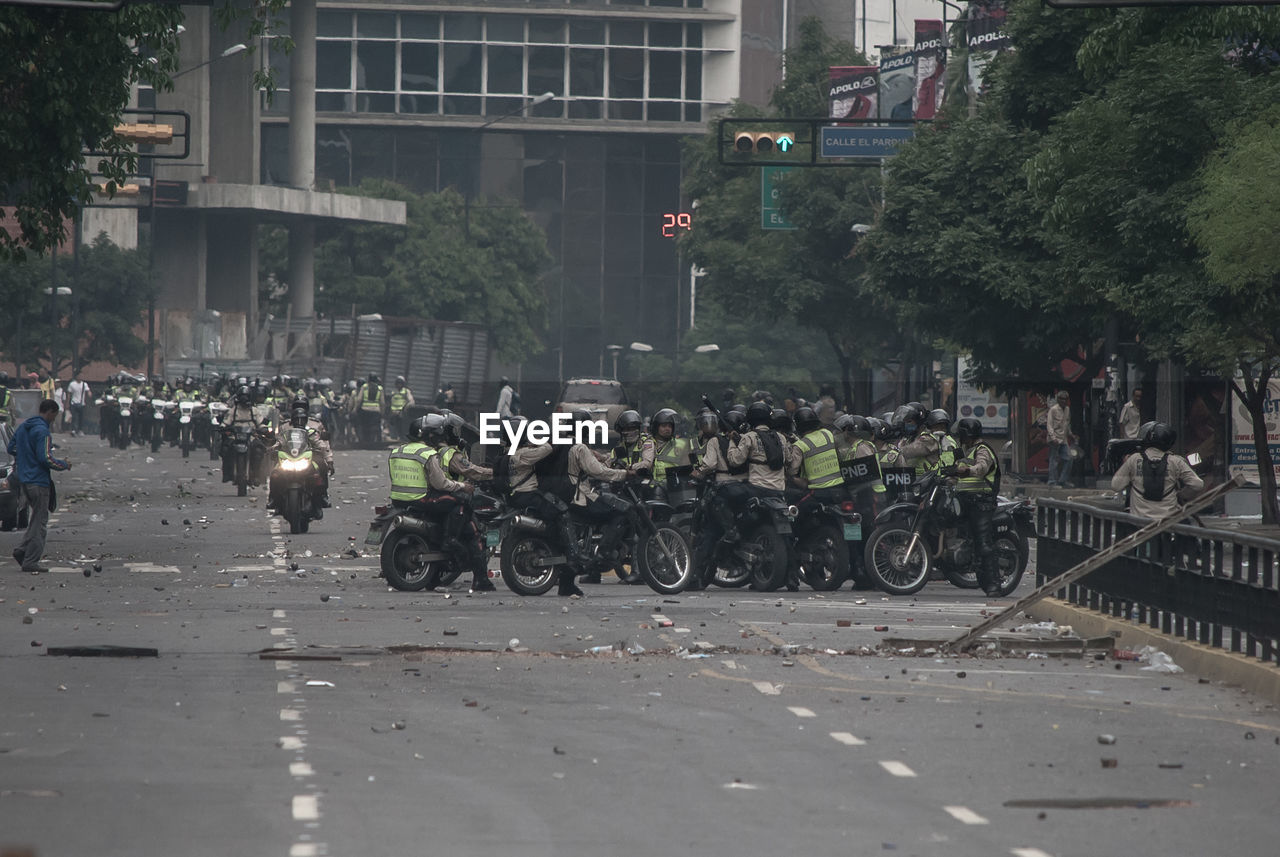 PEOPLE ON ROAD AGAINST BUILDINGS IN CITY