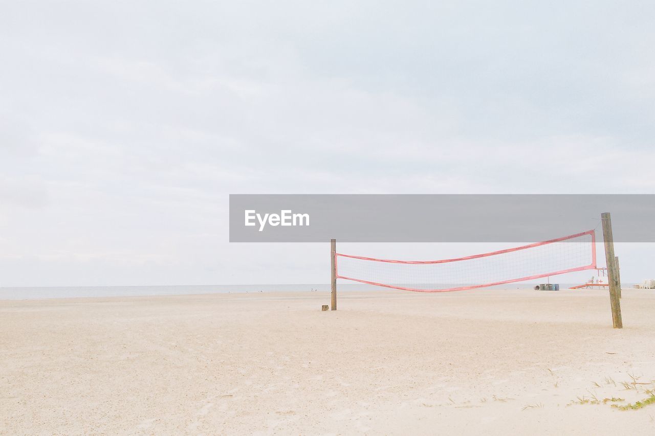 Volleyball net on beach against sky