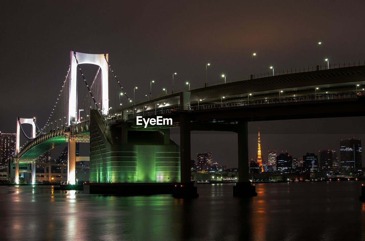 Illuminated rainbow bridge and tokyo tower at night