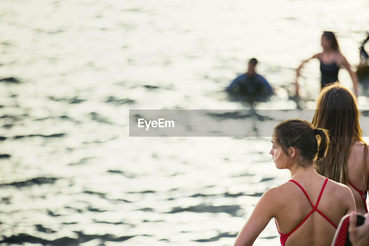 Rear view of teenager wearing swimwear looking at river