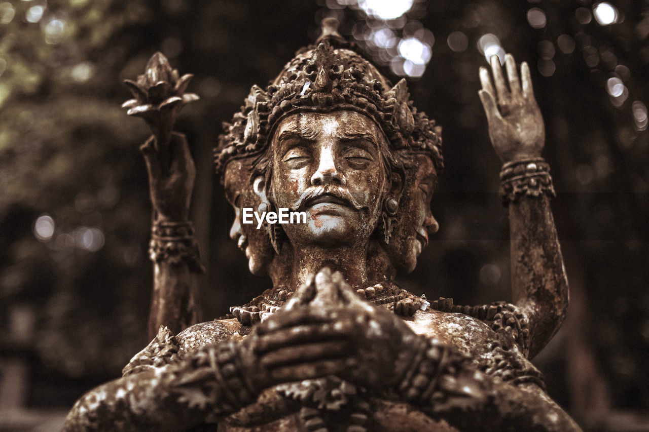 Balinese statue on pedestal. stone figure of the god. water palace of tirta ganga, east bal