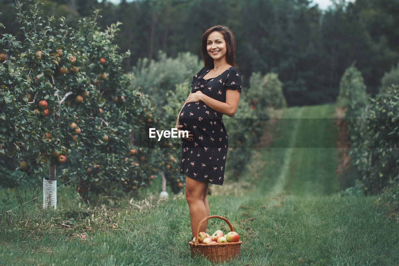 Portrait of pregnant woman standing at farm