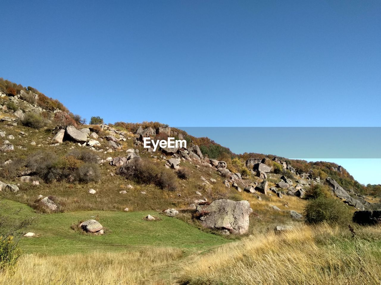 Scenic view of rocky landscape against clear blue sky