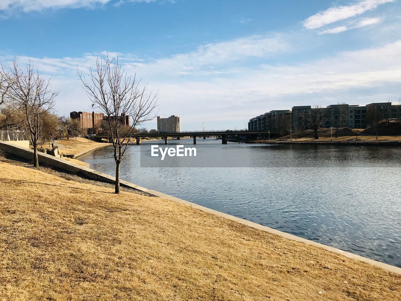 SCENIC VIEW OF CITY BY RIVER AGAINST SKY