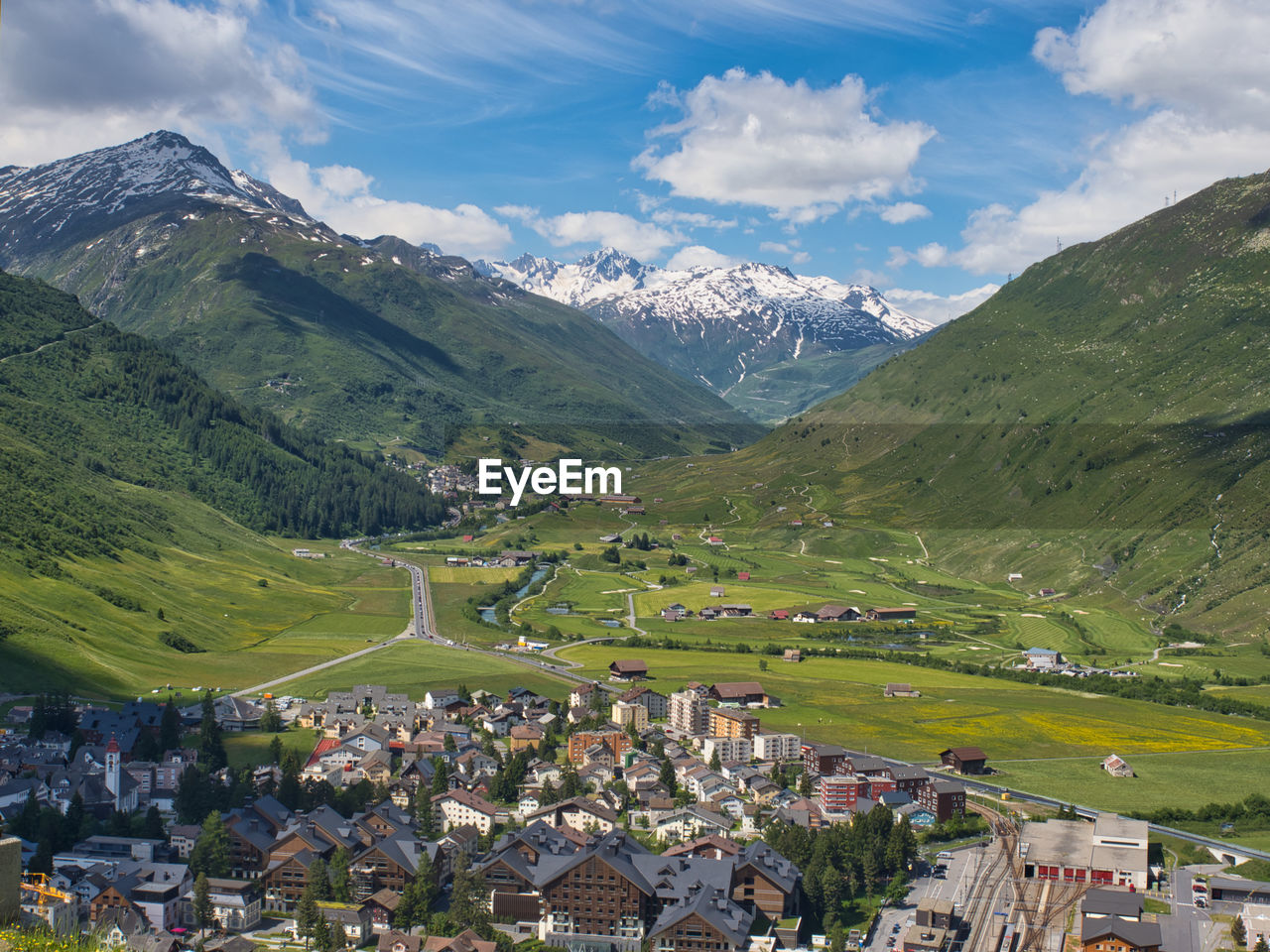 Scenic view of townscape and mountains against sky