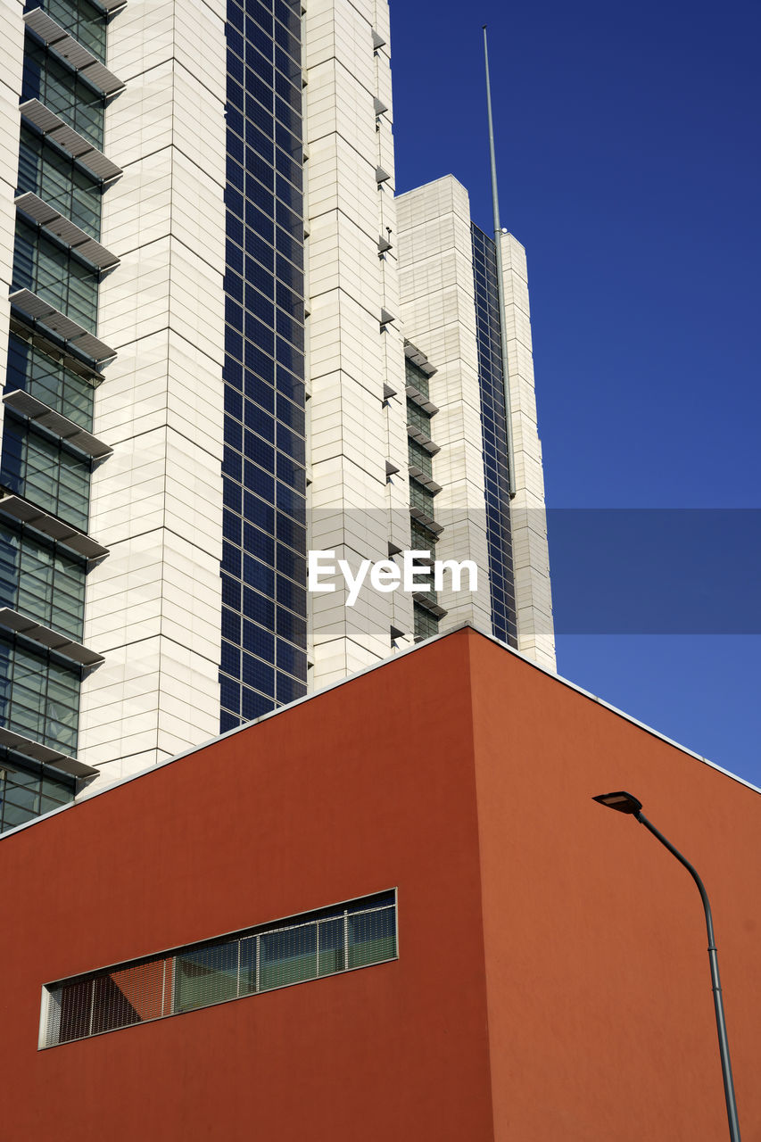 LOW ANGLE VIEW OF MODERN BUILDING AGAINST BLUE SKY