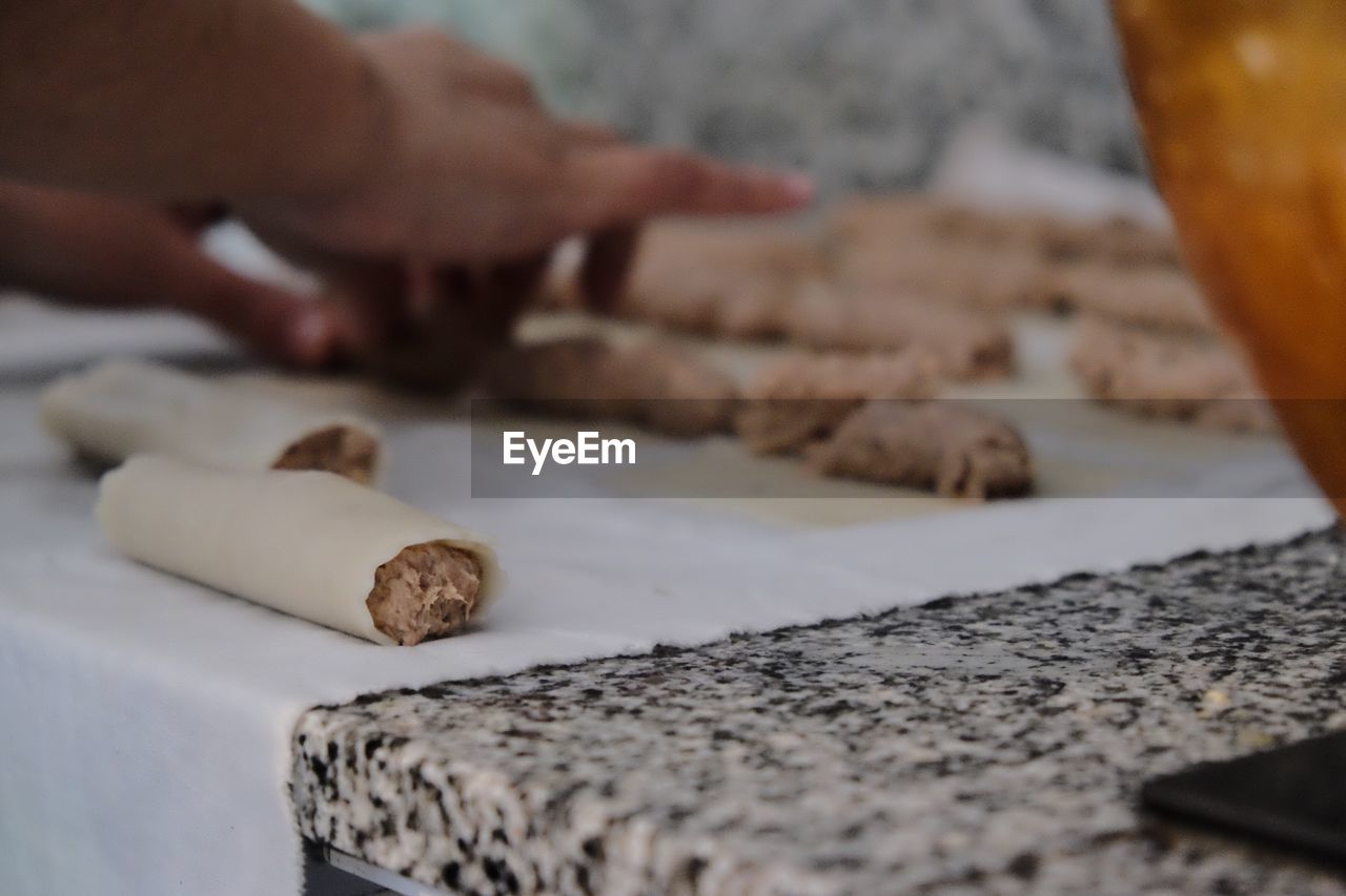 Cropped hands preparing food on table