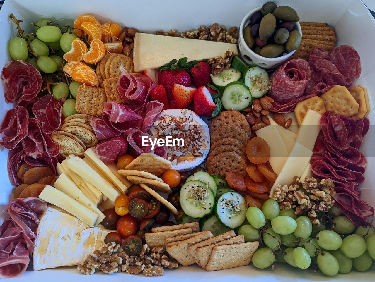 High angle view of a charcuterie board with meats, cheese and vegetables on table 