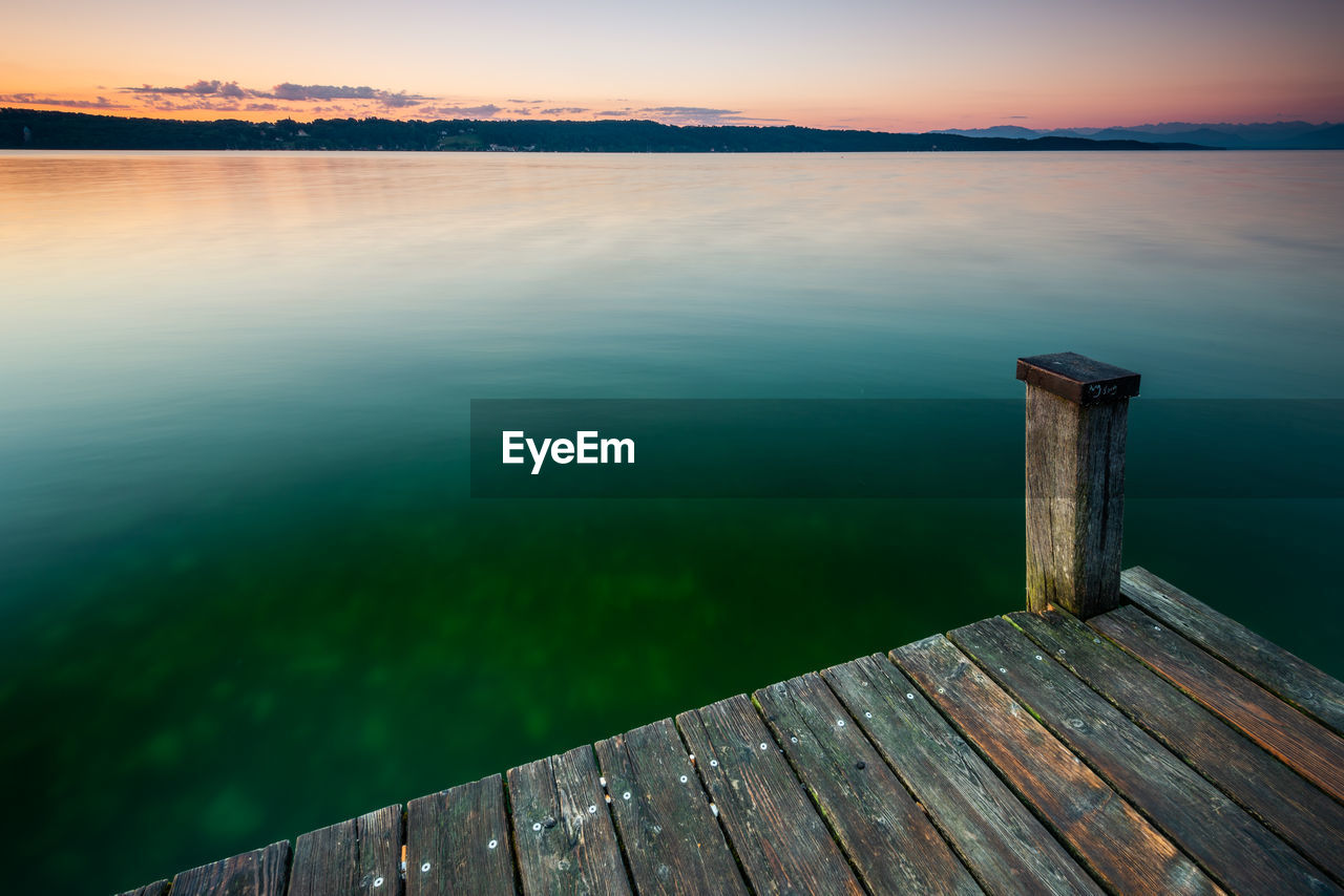 WOODEN PIER ON LAKE AGAINST SKY