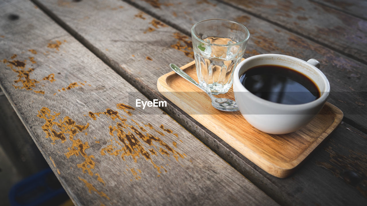 Close-up of tea cup and drinking water on table