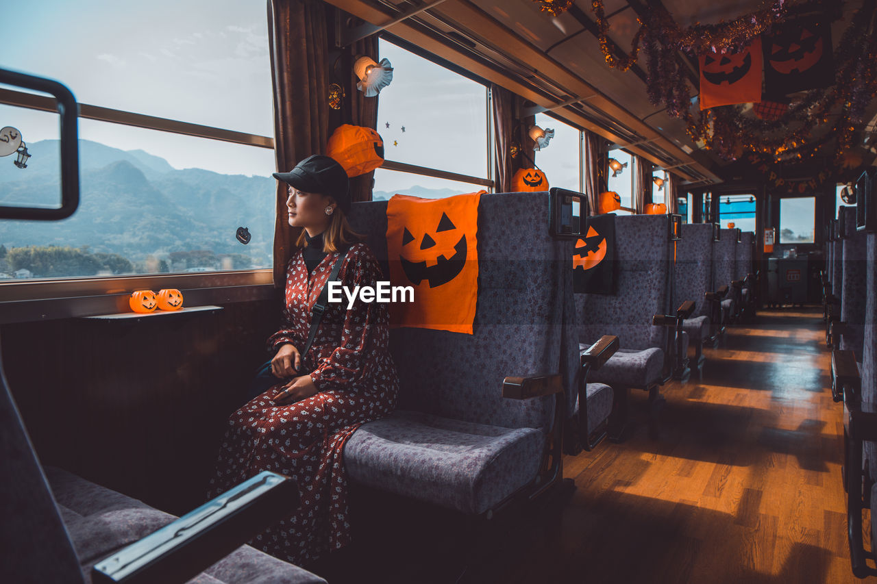 Woman looking through window while sitting in decorated train
