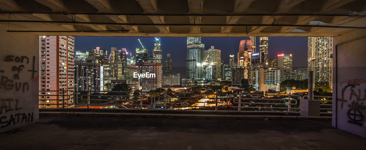 Illuminated buildings seen from parking lot at night