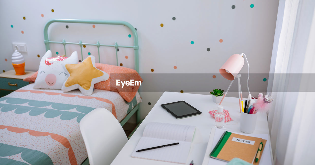 Girl's bedroom with bed and desk decorated in pastel colors