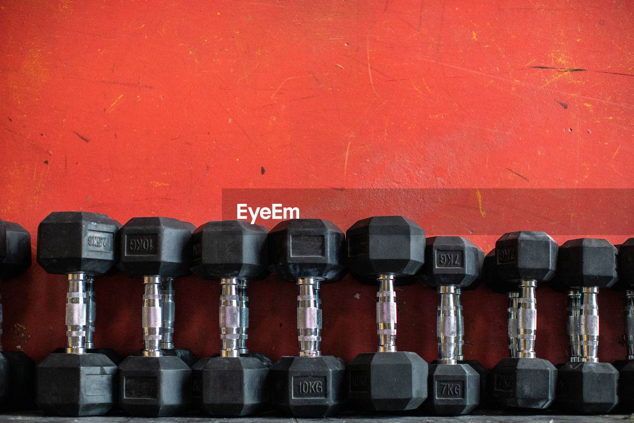 Set of dumbbells lying on rack in gym