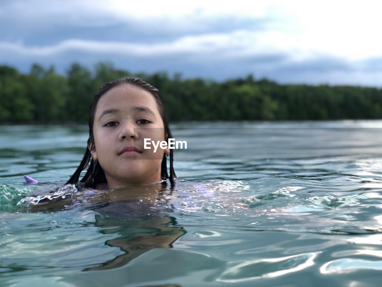 Portrait of girl swimming in river 