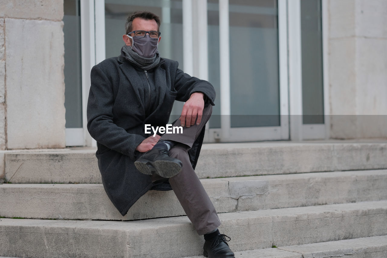 Full length of man sitting outdoors