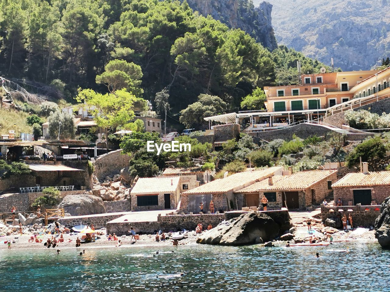 People on boats by sea against buildings