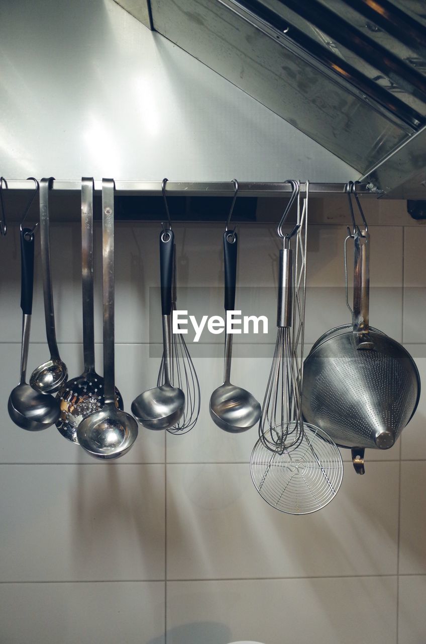 Utensils hanging against wall in kitchen at home