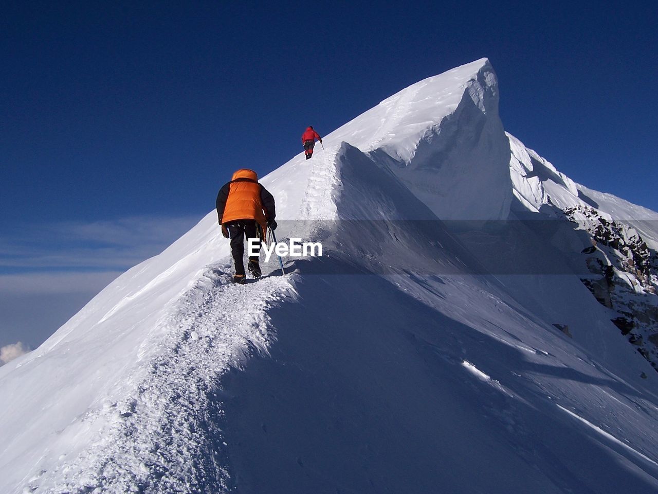 Low angle view of hikers on snow covered mountains