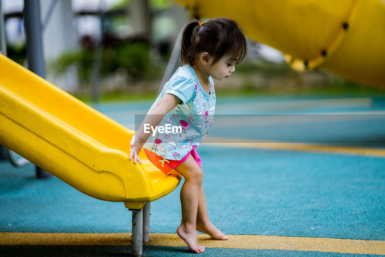 FULL LENGTH OF A GIRL PLAYING WITH SWIMMING POOL