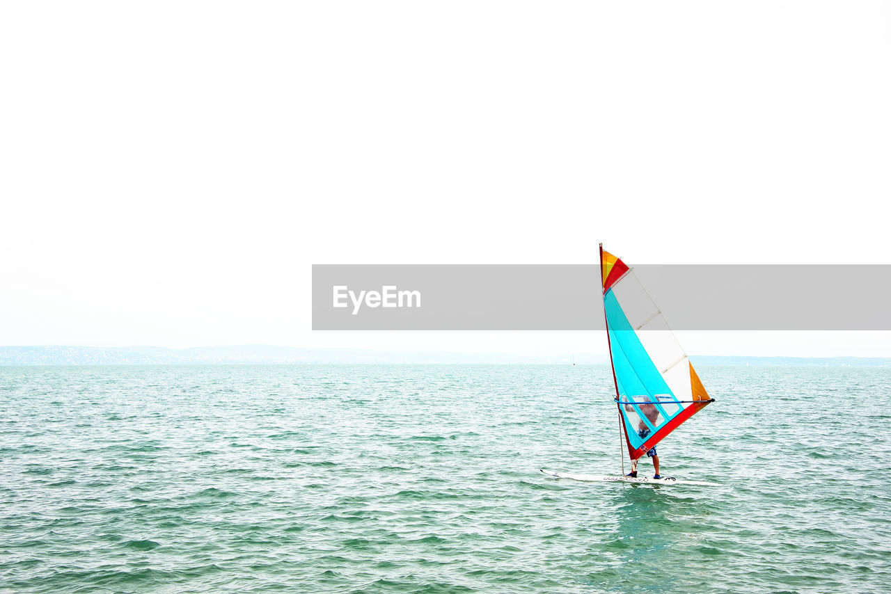 MAN IN SEA AGAINST CLEAR SKY