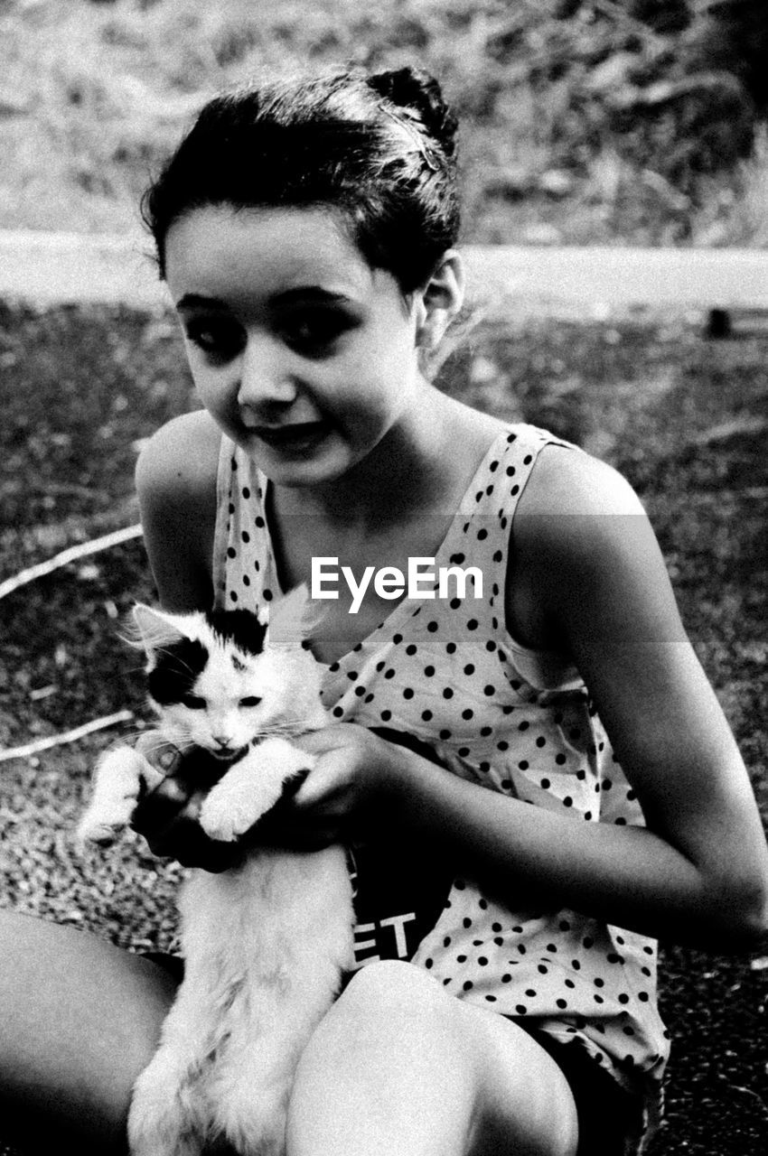 Portrait of smiling girl holding cute kitten