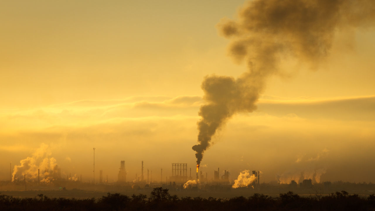 Smoke emitting from chimney against sky at sunset