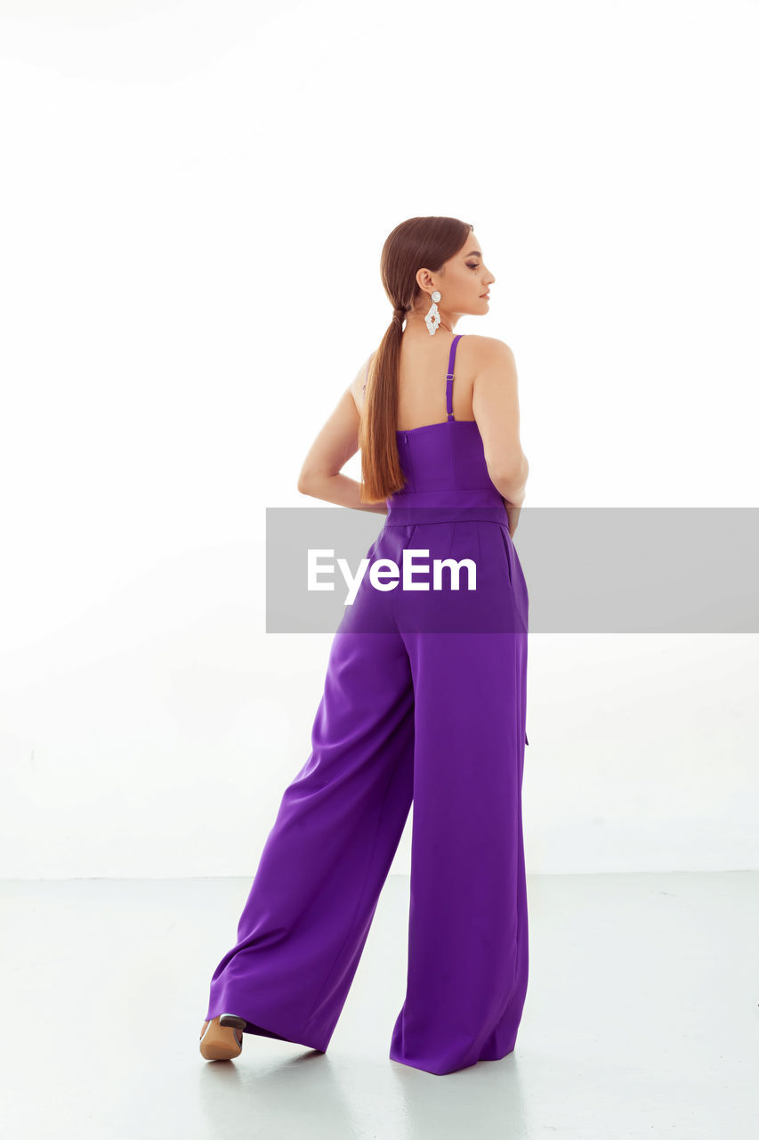purple, adult, women, one person, full length, violet, gown, clothing, studio shot, young adult, fashion, magenta, indoors, white background, dress, standing, portrait, lavender, female, pink, elegance, cocktail dress, lifestyles, copy space, looking, formal wear, hairstyle, side view