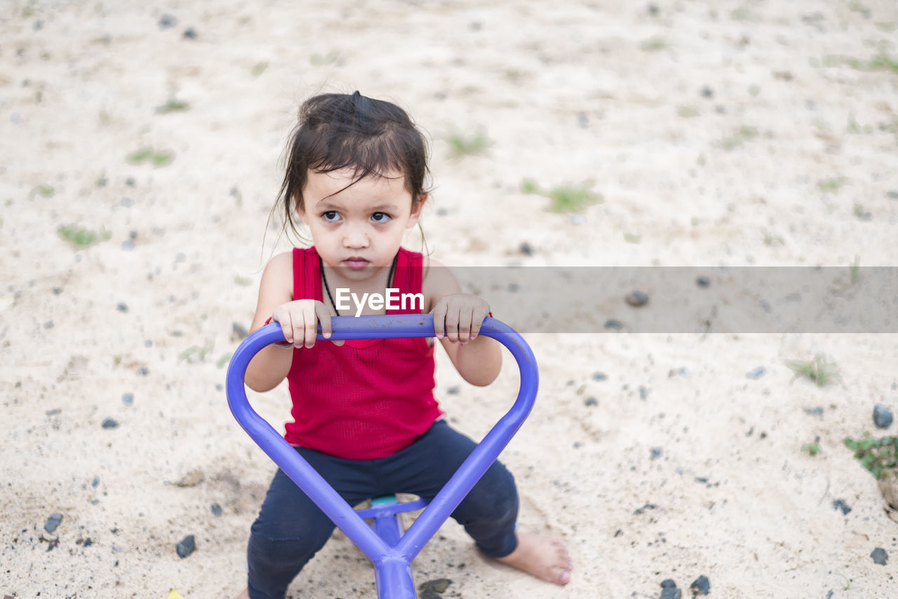 portrait of cute girl playing with toy on field